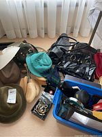 Overview of hats, shoe stretchers, handbags, clutches, accessories in blue tote