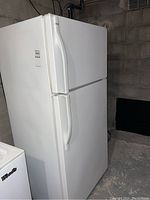 Front view of white Kenmore refrigerator with top freezer