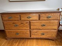 Front view of entire dresser showing seven drawers and metal hardware