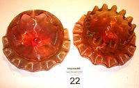 Two hand-blown antique Stourbridge rose glass finger bowls with scalloped edge plates, shown from above displaying rich rose color and gold hue in glass.