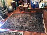 Full view of woven oriental-style area rug under table and chairs