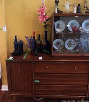 Front view of Vilas two-piece buffet base and glass hutch with decorative items