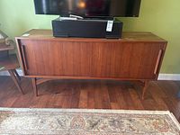 Front view of full cabinet showing two sliding doors, teak veneer top, tapered legs