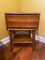 Front view of the Vilas Furniture nightstand showing drawer and tapered legs with metal caps.