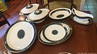 Full view of lot including two covered oval dishes, stack of round plates, large platter and gravy boat with underplate on table