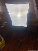 Front view of studio light stand with white softbox diffuser showing fabric diffuser illuminated from inside.