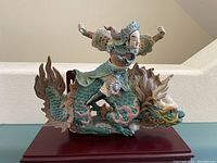 Front and side view of sancai glazed ceramic warrior and dragon figure on base