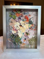 Framed abstract floral oil painting with vibrant colors and textures.