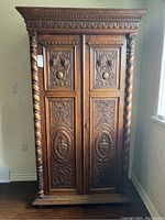 Full frontal view of carved oak wardrobe showing double doors and cornice