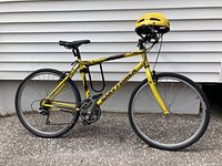 Full left-side view of yellow Gary Fisher Piraña bike with helmet mounted on handlebar