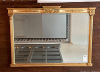 Front view of rectangular gilt framed mirror showing overall condition and reflective surface.