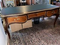 Overall view of desk showing shape, leather top, and ormolu mounts