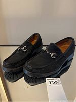 Front-side angled view showing the pair of black suede loafers with silver horsebit, showcasing sole and upper in good condition.