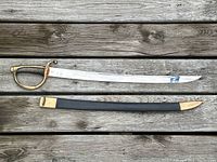 Full view of briquet sabre with blade out of scabbard on wood surface showing full length and condition.