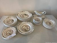 Wide view of entire lot showing all plates, bowls and gravy boat.