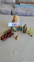 View of the Laughing Buddha, elephant, grapes and smaller figurines on table