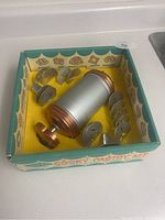 Photo of open box showing cookie pastry press, metal discs, and tips arranged inside.