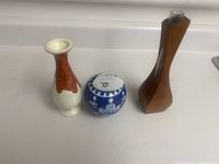 Three small vases on a white surface showing different materials and styles.