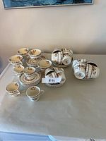 Full assortment of Spode Cowslip teacups and saucers arranged on a table, grouped by size.