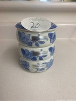 Stacked view of three ceramic teabag holders labeled English Breakfast, Orange Pekoe, and Earl Grey, showing floral blue design.