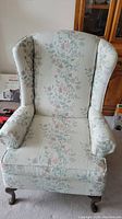 Front view of vintage floral pattern arm chair showing upholstery and overall condition.