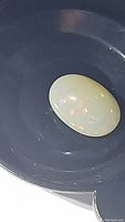 Close-up photo of 3.31ct oval cabochon Ethiopian opal with galaxy flash color play