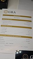 Photo of GRA grading report for the moissanite gemstone showing certification details including 0.5 carat weight, VVS1 clarity, D color and excellent polish and symmetry.