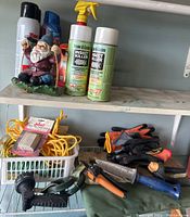 Photo of gardening tools and accessories including gloves, ropes, cutters, knee pads, food spikes on a shelf