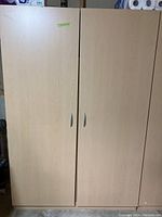 Front view of closed large storage cabinet with two doors and silver handles