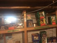 Shelves with multiple boxed Christmas village houses and shops, assorted sizes and designs