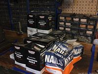 Boxes of Homeshield Hy-tensil alloy aluminum nails, 1 1/2 inch plain shank, stored on a shelf with plastic drawer storage units behind.