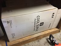 Boxed Cool Surge Portable Air Cooler showing brand name and product type on side panel.