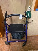 Front view of the blue Drive walker showing seat, brakes, and storage pouch.
