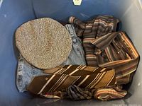 Photo showing a brown striped necktie, flat cap, pair of blue jeans, and a brown striped casual long sleeve shirt.