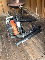 Both the Stihl handheld and Echo backpack leaf blowers are displayed on a wooden floor in a shed, showing signs of dirt and weathering.