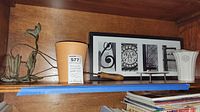 Shelf showing all four items including framed print, candle holder, plant pot, and vase