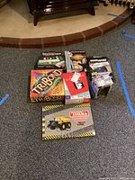Full lot of vintage games including boxes for Texas Hold 'Em poker set, Tonka Construction Site jigsaw book, Scattergories, Deal or No Deal DVD, Catchphrases, and Best of TriBond board game.