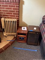 Three appliances: oil-filled radiator heater, Reliable Products metal heater, Whirlpool humidifier in wood-tone casing.