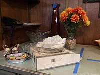 Overview of glassware and decor items on table including punch bowl set, vases, serving bowls, and decorative dish