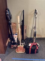 Photo showing all five main cleaning appliances including vacuums, floor polisher, steam cleaner, steamer, and accessories.