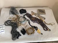 Full assortment of jewelry laid out including necklaces, bracelets, earrings, and compact