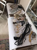 Overall view of table with assorted necklaces, bracelets, rings, earrings and accessories