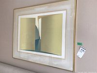 Framed print with abstract beige and gold shapes, matted and under glass with a gold metal frame.
