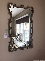 Full front view of the wooden framed wall mirror hung on a wall.