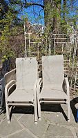 Four metal frame outdoor chairs with beige mesh seats and backs. Chairs show some dirt and wear from outdoor exposure.