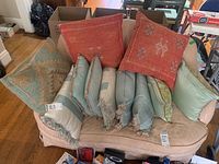 Wide view of all 12 throw pillows arranged on a sofa, showing their patterns and colors.
