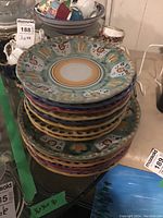 Stack of colorful ceramic plates in various hand-painted patterns