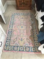 Overall view of the full area rug on carpeted floor, showing its pattern and color scheme.