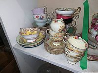 General shelf display showing assorted teacups, saucers, creamer and bowl.