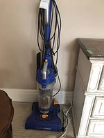 Full view of blue Eureka PowerSpeed upright vacuum with handle, cord, and dust container visible